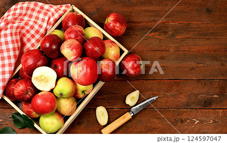Autumn composition of apples in a box on a sunny wooden table, thanksgiving background, harvest, healthy natural food concept, detox diet and body cleansing, screen banner, cafe, restaurant, selective 124597047