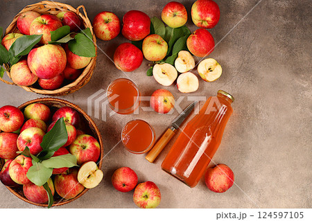 Apple cider, juice or fermented drink and fresh apples on concrete table. Autumn banner. Diet and weight loss concept. Healthy eating, body detoxification, apples help cleanse the body and reduce Apple cider, juice or fermented drink and fresh apples on concrete table. Autumn banner. Diet and weight loss concept. Healthy eating, body detoxification, apples help cleanse the body and reduce 124597105