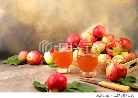 Apple cider, juice or fermented drink and fresh apples on concrete table. Autumn banner. Diet and weight loss concept. Healthy eating, body detoxification, apples help cleanse the body and reduce 124597110