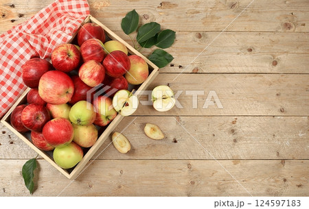 Autumn composition of apples in a box on a sunny wooden table, thanksgiving background, harvest, healthy natural food concept, detox diet and body cleansing, screen banner, cafe, restaurant, selective 124597183