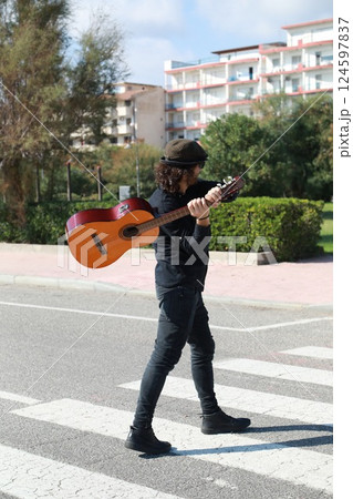 Young Man Plays Guitar On Pedestrian Crossings Of A Street In Summer 124597837