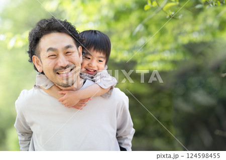 新緑背景で子供をおんぶするお父さんのクローズアップ 仲良し親子(父子)イメージ 新緑背景で子供をおんぶするお父さんのクローズアップ 仲良し親子(父子)イメージ 124598455