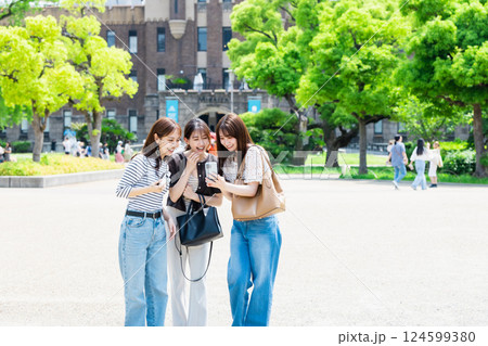 女子旅 カメラを持って大阪城公園を観光する若い女性 女子旅 カメラを持って大阪城公園を観光する若い女性 124599380