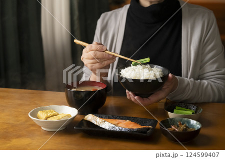 朝食のおかずを箸で持ち上げる 朝食のおかずを箸で持ち上げる 124599407