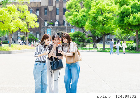 女子旅  カメラを持って大阪城公園を観光する若い女性 124599532