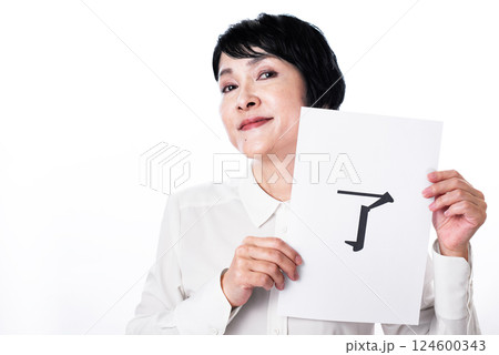 了と書かれた紙を掲げ満足気な表情の中年女性 了と書かれた紙を掲げ満足気な表情の中年女性 124600343