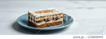 Delicious layered dessert served on a blue plate in a bright kitchen setting 124600945