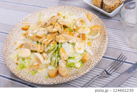Caesar salad with sawn eggs on a plate on a gray background Caesar salad with sawn eggs on a plate on a gray background 124602230