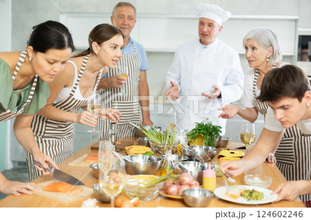 Cheerful woman drinking wine and talking during group culinary masterclass 124602246