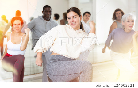 Smiling girl learning dynamic dances in group choreography class Smiling girl learning dynamic dances in group choreography class 124602521