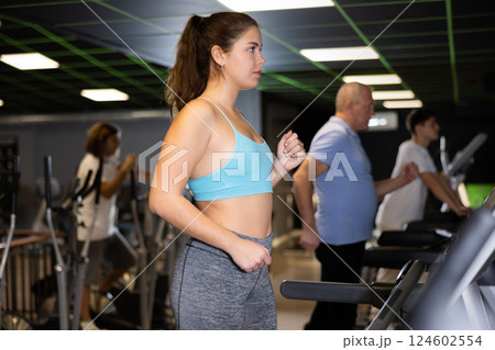 Woman riding cardiovascular trainers in gym 124602554