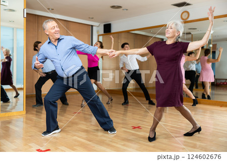 Elderly pair practicing ballroom dance in dance studio Elderly pair practicing ballroom dance in dance studio 124602676