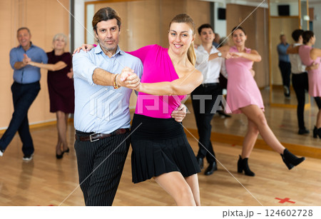 Happy couple performing a paired dance in ballroom 124602728