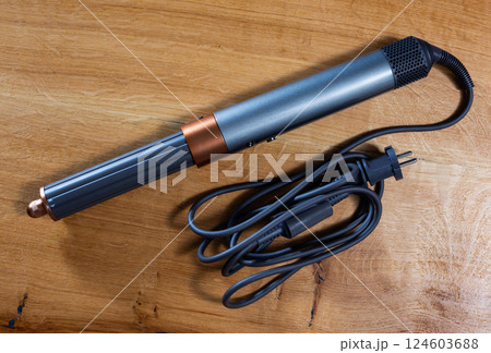 Hair styling tool for creating curls on wooden table 124603688