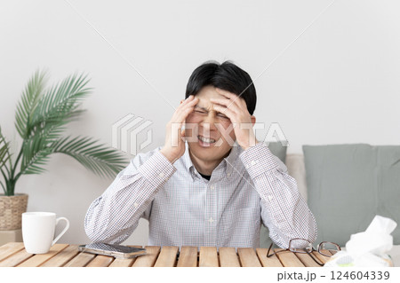 体調不良の男性　頭痛　 124604339