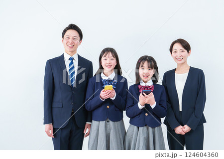 スマートフォンを持つ女の子と両親 スマートフォンを持つ女の子と両親 124604360