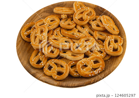 Freshly baked sesame pretzels served on a wooden plate for snacking 124605297