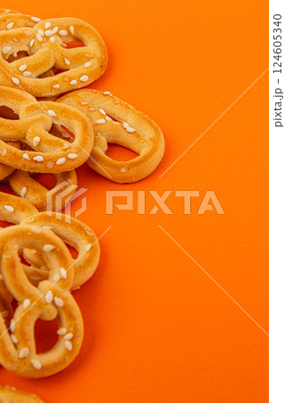 Delicious pretzels on a vibrant orange background Delicious pretzels on a vibrant orange background 124605340
