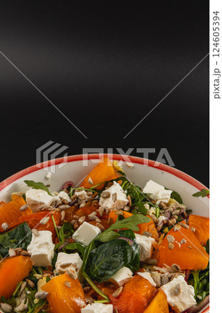 Fresh salad featuring chicken, persimmon, feta, and sunflower seeds 124605394