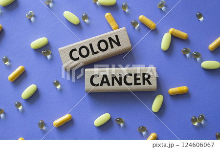 Colon Cancer symbol. Concept word Colon Cancer on wooden blocks. Beautiful purple background with pills. Medicine and Colon Cancer concept. Copy space 124606067