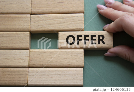 Offer symbol. Concept word offer on wooden blocks. Beautiful grey green background. Businessman hand. Business and offer concept. Copy space. Offer symbol. Concept word offer on wooden blocks. Beautiful grey green background. Businessman hand. Business and offer concept. Copy space. 124606133