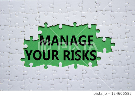 Risks symbol. Concept words Manage your Risks on white puzzle. Beautiful green background Business and Manage your Risks concept. Copy space. 124606583
