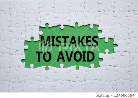 Mistakes symbol. Concept words Mistakes to Avoid on white puzzle. Beautiful green background Business and Mistakes to Avoid concept. Copy space. 124606584