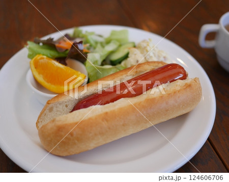 テーブルに置かれたコーヒー　おいしいホットドッグ　と丁寧な仕事　コピースペース 124606706