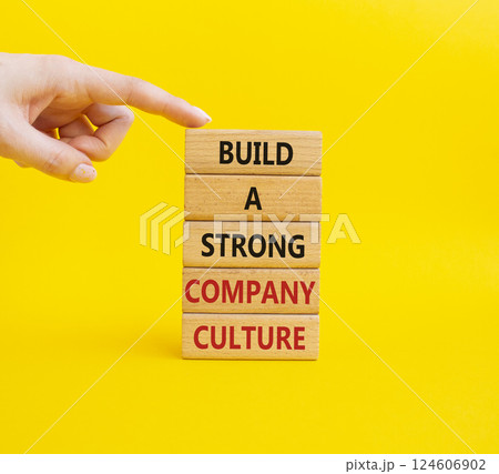 Company culture symbol. Wooden blocks with words Build a strong company culture. Businessman hand. Beautiful yellow background. Business and Company culture concept. Copy space. Company culture symbol. Wooden blocks with words Build a strong company culture. Businessman hand. Beautiful yellow background. Business and Company culture concept. Copy space. 124606902