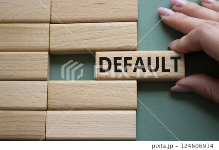Default symbol. Concept word Default on wooden blocks. Businessman hand. Beautiful grey green background. Business and Default concept. Copy space. 124606914