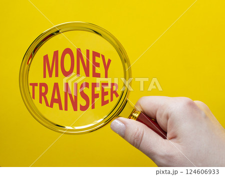 Money Transfer symbol. Magnifying Glass with Concept word Money Transfer. Businessman hand. Beautiful yellow background. Business and Money Transfer concept. Copy space Money Transfer symbol. Magnifying Glass with Concept word Money Transfer. Businessman hand. Beautiful yellow background. Business and Money Transfer concept. Copy space 124606933