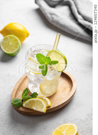 Cocktail or lemonade mojito with fresh lemon, lime, mint and ice on a wooden plate  124607340