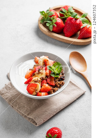 Natural Greek yogurt with homemade chocolate granola, strawberries and banana in a bowl Natural Greek yogurt with homemade chocolate granola, strawberries and banana in a bowl 124607352