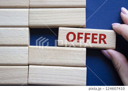 Offer symbol. Concept word offer on wooden blocks. Beautiful deep blue background. Businessman hand. Business and offer concept. Copy space. Offer symbol. Concept word offer on wooden blocks. Beautiful deep blue background. Businessman hand. Business and offer concept. Copy space. 124607410
