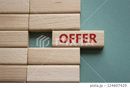 Offer symbol. Concept word offer on wooden blocks. Beautiful grey green background. Business and offer concept. Copy space. Offer symbol. Concept word offer on wooden blocks. Beautiful grey green background. Business and offer concept. Copy space. 124607420