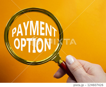 Payment Option symbol. Concept words Payment Option on magnifying glass. Businessman hand. Beautiful orange background. Business and Payment Option concept. Copy space. 124607426