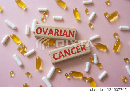 Ovarian Cancer symbol. Concept word Ovarian Cancer on wooden blocks. Beautiful pink background with pills. Medicine and Ovarian Cancer concept. Copy space 124607745