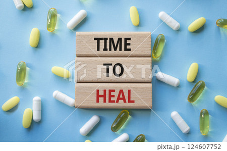 Medicine symbol. Concept words Time to Heal on wooden blocks. Beautiful blue background with pills. Medicine concept and Time to Heal. Copy space 124607752