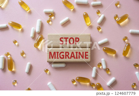 Stop Migraine symbol. Concept word Stop Migraine on wooden blocks. Beautiful pink background with pills. Medicine and Stop Migraine concept. Copy space 124607779