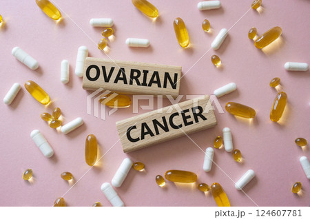 Ovarian Cancer symbol. Concept word Ovarian Cancer on wooden blocks. Beautiful pink background with pills. Medicine and Ovarian Cancer concept. Copy space 124607781