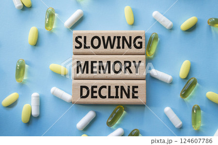 Slowing Memory Decline symbol. Concept words Slowing Memory Decline on wooden blocks. Beautiful blue background with pills. Healthcare and Slowing Memory Decline concept. Copy space. 124607786
