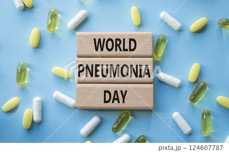 Medicine symbol. Concept words World Pneumonia Day on wooden blocks. Beautiful blue background with pills. Medicine concept and World Pneumonia Day. Copy space 124607787