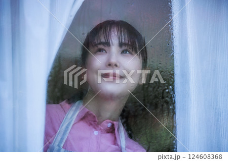 窓から外を見る女性 124608368