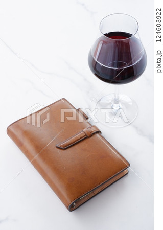 茶色の革のシステム手帳と赤ワインのグラス 茶色の革のシステム手帳と赤ワインのグラス 124608922