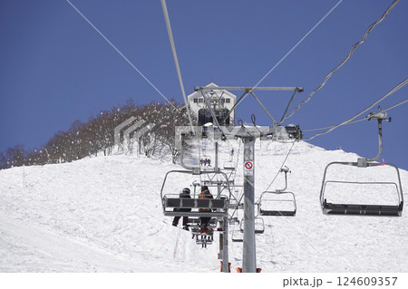 快晴のスキー場 頂上へ続くリフトと真っ白なゲレンデ 124609357
