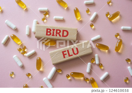 Bird Flu symbol. Concept word Bird Flu on wooden blocks. Beautiful pink background with pills. Medicine and Bird Flu concept. Copy space 124610038