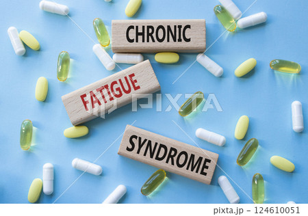 Chronic Fatigue Syndrome symbol. Concept word Chronic Fatigue Syndrome on wooden blocks. Beautiful blue background with pills. Medicine and Chronic Fatigue Syndrome concept. Copy space 124610051