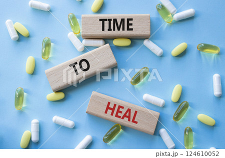 Medicine symbol. Concept words Time to Heal on wooden blocks. Beautiful blue background with pills. Medicine concept and Time to Heal. Copy space 124610052