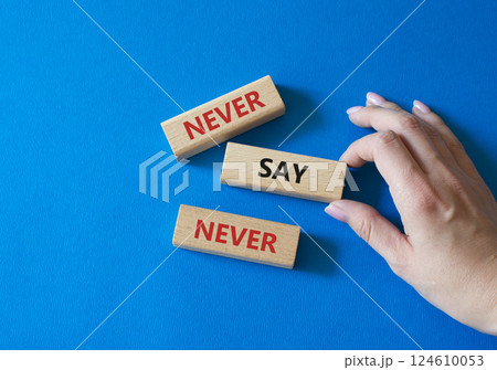 Never say Never symbol. Concept words Never say Never on wooden blocks. Businessman hand. Beautiful blue background. Business and Never say Never concept. Copy space 124610053