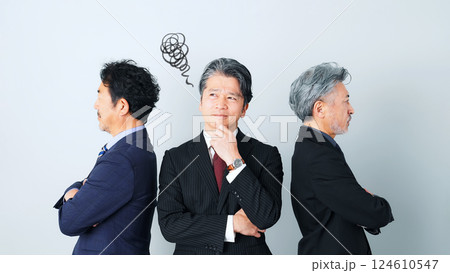 同僚の間に立って悩むミドルエイジ男性ビジネスパーソン 同僚の間に立って悩むミドルエイジ男性ビジネスパーソン 124610547